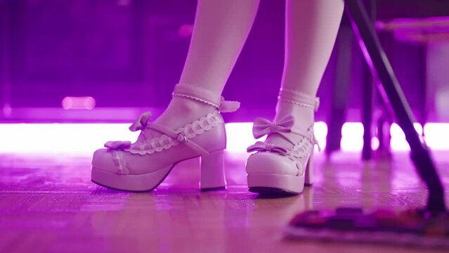 Maid in pink lolita platform shoes dancing with mop while cleaning close-up 4K