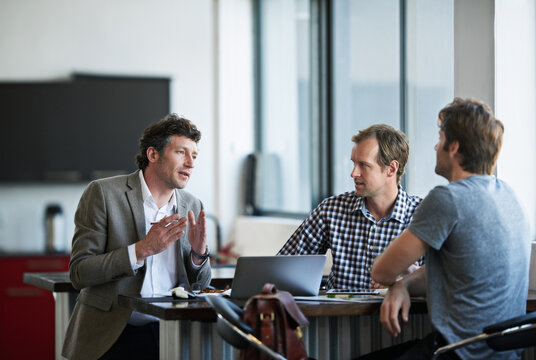 So heres my idea.... Cropped shot of three businessman discussing work in the office.
