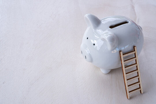 A wooden staircase leads to the goal of success in saving money and a piggy bank is placed next to each other on the office table. financial planning for efficiency concept.