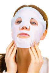 Woman applying sheet mask on face