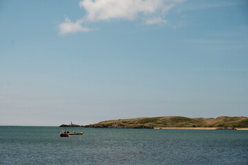 boat on the sea with lighthouse in the background