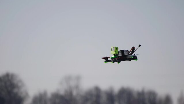 The drone flies in a winter field in nature. Taking a close-up of the device