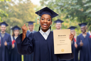 education, graduation and people concept - happy graduate student woman in mortarboard and bachelor gown showing diploma of university and making winning gesture over group of people on background