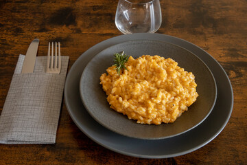 butternut risotto in a plate on a wooden background