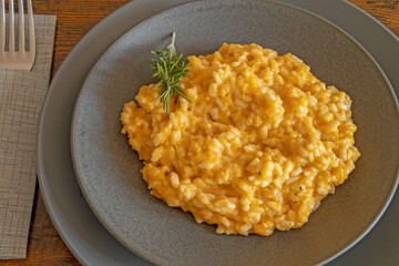 butternut risotto in a plate on a wooden background