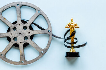 Golden film award statue with reel video tape
