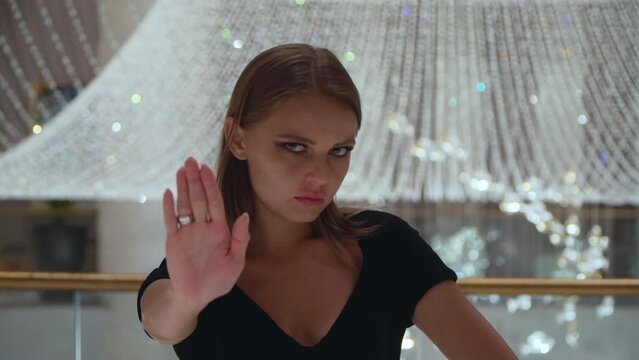 The woman shows gestures stop. European girl refuses. Caucasian girl looks with disgust. The woman shows antipathy. 