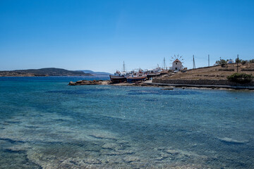 Greece. Koufonisi island, Cyclades. Windmill, shipyard for wooden fishing boat, sea, blue sky.