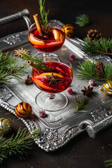 Mulled red cherry wine or punch with slice of orange and anise star and cinnamon on a tray. Christmas beverage.