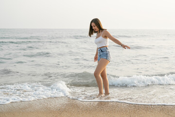 Fototapeta na wymiar Happy woman smiling on the shore of the beach