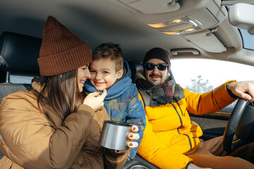 Mother, father and child traveling by car on a vacation to the mountains in winter