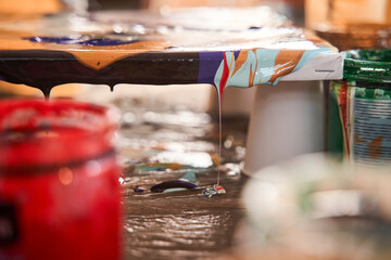 Vivid abstract drawing masterpiece with fresh wet paints laying at the table
