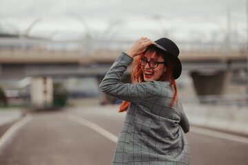 young woman with red hair laughing with braces