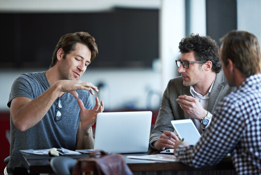 So it goes like this.... Cropped shot of three businessman discussing work in the office.