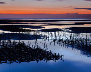 Obraz premium Beautiful landscape of sea level reflect fantasy dramatic sunset sky in wetlands , the famous travel attractions in Changhua Binhai Industrial Zone, Taiwan. (彰濱)