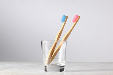 couple and love concept: pink and blue bamboo toothbrushes in a glass with copy space for your text