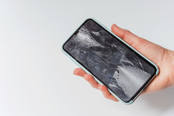 A broken smartphone in hand on a white background. The broken screen of the gadget . Broken Touch...