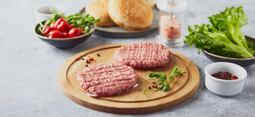 Raw veal mince Burger steak cutlets on wooden cutting board