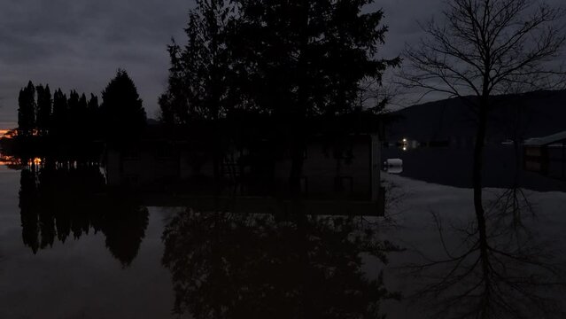 Flooded tree's and buildings sit in deep water during sunset