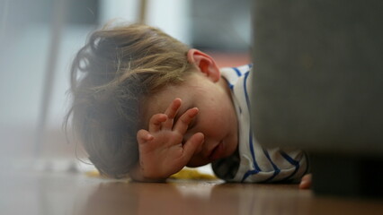 Angry little boy lying on floor feeling upset and boredom at home