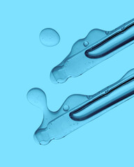 Pipette with cosmetic product in water with bubbles.