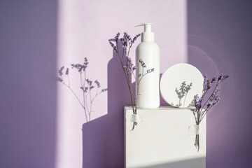Jars of cosmetics on a purple background with lavender.