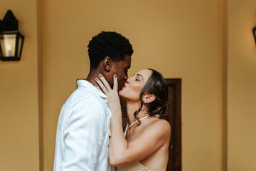 Couple kissing passionately while standing on their porch