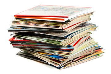 A messy pile of old, colorful magazines on light background.