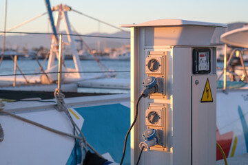 Close up of the charging station in a port. Moored boats are charging with electricity. Zero...