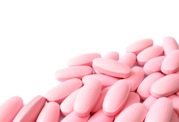Obraz na płótnie Canvas Pile of pink tablets on white background with copy space