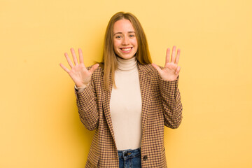 pretty caucasian woman smiling and looking friendly, showing number nine or ninth with hand...