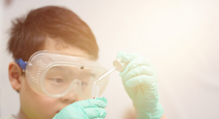 child use dropper in tube for education in learning laboratory and research with fun in chemical technology and biology like scientist