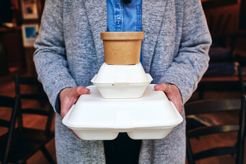 Frau hält take away Boxen mit Essen in Ihrer Hand von Lieferdienst