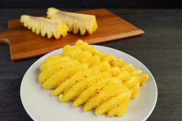 Closeup slices of fresh ripe pineapple on a white plate ready to serve