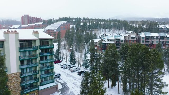 Aerial flight towards Breckenridge apartment lodges in snowy overcast weather