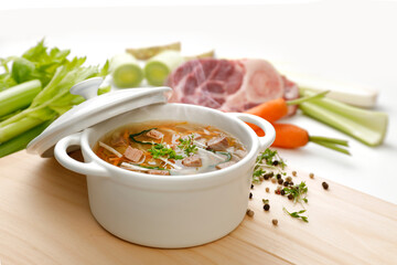 Dampfende Brühe mit Fleisch und frischem Gemüse