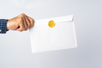 Male hands holding an envelope with a wax seal
