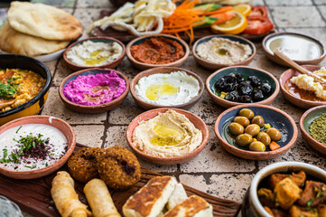 Fototapeta na wymiar Traditional Turkish Village Breakfast on the ceramic table with pastries, vegetables, greens, spreads, cheeses, fried eggs, jams. Top view