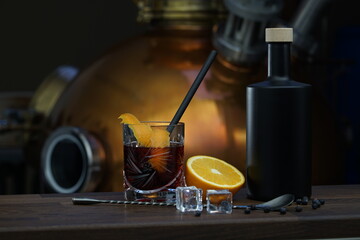 Gin cocktail with black ceramic bottle in front of distillery.