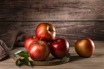 Fresh apples on a plate on a wood background.