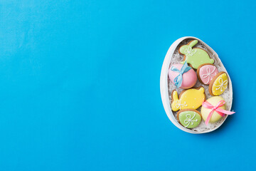 Colorful easter cookies in basket with Multi colors Easter eggs on colored background . Pastel color Easter eggs. holiday concept with copy space