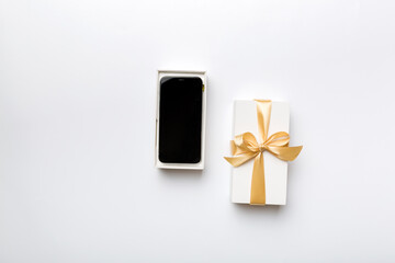 Opened gift box with gold ribbon and smartphone on color background, top view. Blank open box packaging mockup , Template for your design - branding mockup