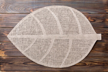 Top view of leaf shaped tablecloth for food on wooden background. Empty space for your design