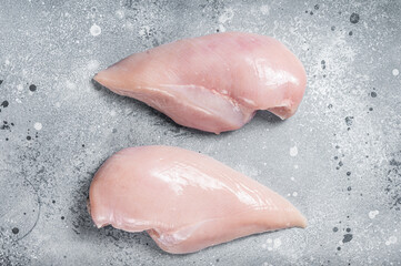 Raw chicken breast fillet on butcher table. Gray background. Top view