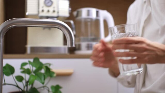 Hands of man filling water at kitchen faucet. Drink daily rate of water, glass of drinking water, healthy lifestyle. Thirsty woman, glass of pure water, enjoy morning daily medical habit at home