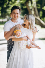 Young couple with their baby daughter in park