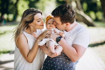Young couple with their baby daughter in park