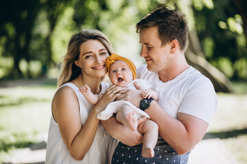 Young couple with their baby daughter in park