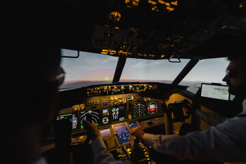 blurred professionals piloting airplane in evening during sunset.