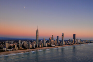 Fototapeta na wymiar Moon setting at dusk over Gold Coast cityscape